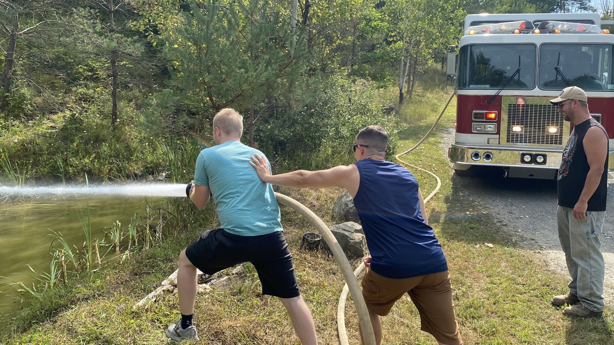 Guests take part in a supervised fire hose experience beside Engine 29-1
